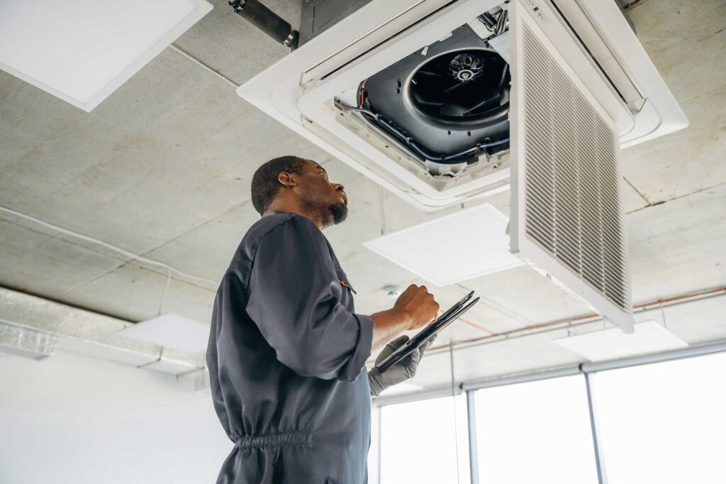 A repairman fixing a broken ventilation