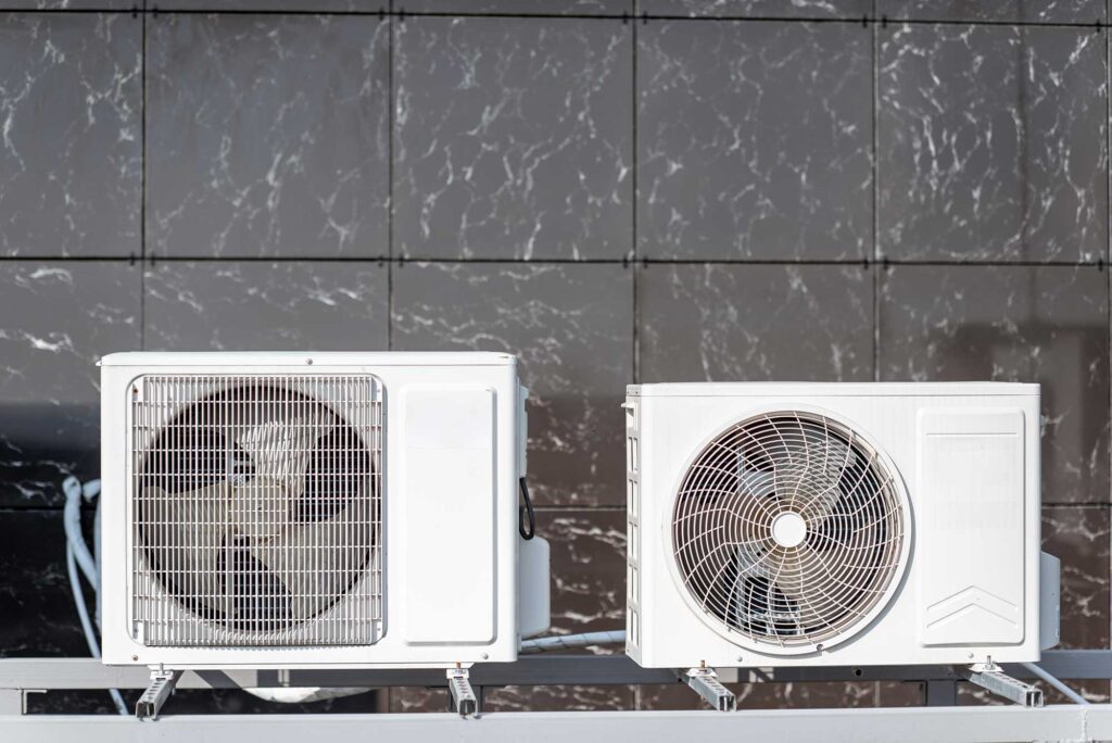 Two air conditioners positioned on a sturdy metal rack,